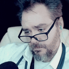a man with a beard wearing glasses and earbuds