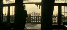 a man standing on a balcony looking out at the city