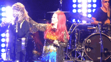 a woman with red hair is singing into a microphone