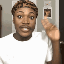 a man wearing a headband and a white shirt is waving his hand .