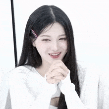 a woman with long black hair making a peace sign