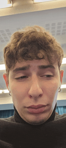 a close up of a man 's face with a turtleneck on