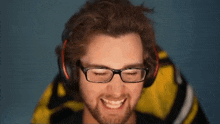 a man wearing glasses and headphones is smiling and making a funny face .
