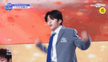 a man in a suit and tie is dancing on a stage with his hands in the air .