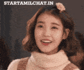 a woman with a flower in her hair is smiling in front of a starttamilchat.in logo
