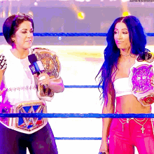 two women are standing in a wrestling ring and one of them is wearing a purple belt