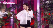 a woman in a white shirt and black shorts is standing on a stage .