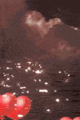 red heart shaped balloons are floating in the air