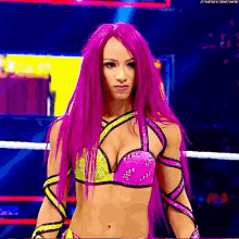 a woman with purple hair is standing in a wrestling ring wearing a bikini top .