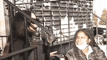 a woman wearing a mask talks to another woman on a staircase