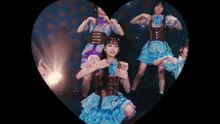 a group of girls in blue and purple dresses are dancing in a heart shaped frame