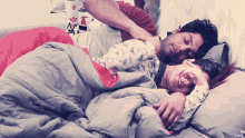 a man and a woman are sleeping on a bed with a fire extinguisher in the background