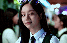 a woman wearing a cat ear headband looks at the camera