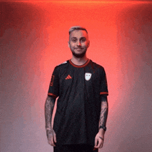 a man wearing a black adidas shirt is smiling