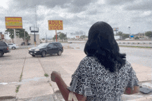 a woman is standing in front of an adult video sign
