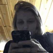 a woman with black eyes is looking at her phone