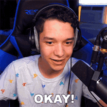 a young boy wearing headphones and a white shirt says okay