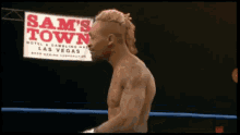 a man in a boxing ring with a sign that says sam 's town in the background