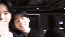 a man and a woman are standing next to each other in a dark room and laughing .