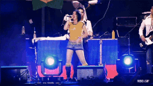 a woman singing into a microphone on a stage with a rbd.gif watermark
