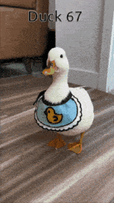 a white duck wearing a blue apron with a yellow duck on it