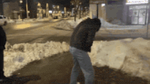 a man in a brown jacket is standing in the snow near a pizza hut