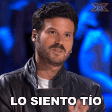 a man with a beard wearing a leather jacket says lo siento tio