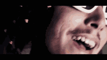 a close up of a man 's face with a mustache wearing sunglasses .