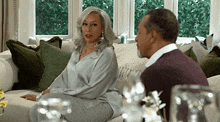 a man and a woman are sitting on a couch and talking to each other