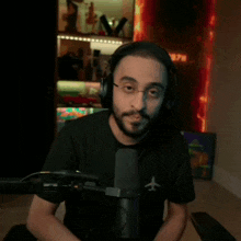 a man wearing headphones is sitting in front of a microphone with an airplane on his shirt