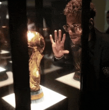 a man wearing glasses is looking at a trophy