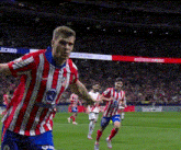 a soccer player wearing a red and white striped shirt with the number 3 on it