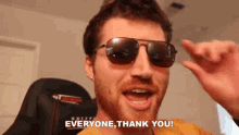 a man wearing sunglasses and a yellow shirt says everyone thank you