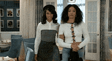 two women are posing for a picture in a living room