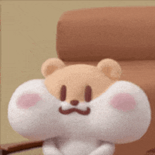 a stuffed animal with a big mouth is sitting on a chair with its eyes closed .