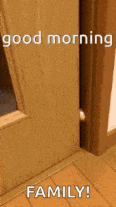 a cat peeking out of a wooden door with the words `` good morning family '' written on it .