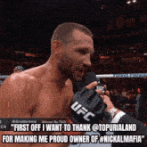a man in a ufc glove is talking into a microphone