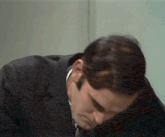 a man in a suit and tie looks down