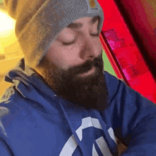 a man with a beard wearing a carhartt hat