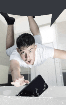 a man in a white shirt is laying on his stomach on a table