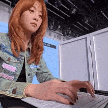 a woman with red hair is typing on a laptop