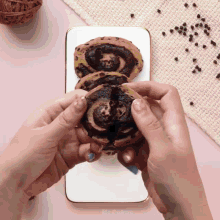 a close up of a person holding a cookie that says cakes