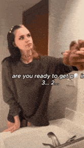 a woman is standing in front of a bathroom sink with the words " are you ready to get p " on the bottom