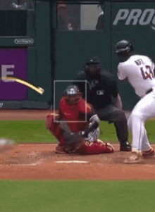 a baseball player is swinging at a ball with the number 86 on the catcher 's helmet