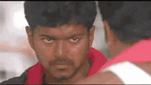 a close up of a man 's face looking at another man .