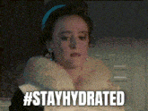 a woman in a fur coat says #stayhydrated in a pixelated image