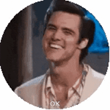 a man in a suit is smiling in a circle and saying ok .