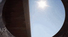 looking through a hole in a wall at the sun