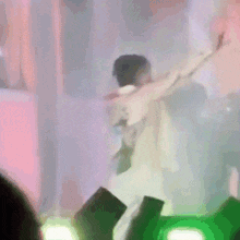 a man is standing on a stage with his arms outstretched .