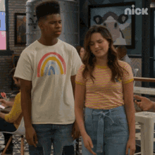 a man and a woman are standing next to each other in front of a sign that says nick on it